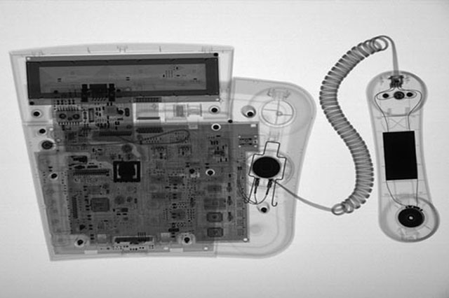 Röntgenbild eines Tischtelefons mit einem Abhörsender